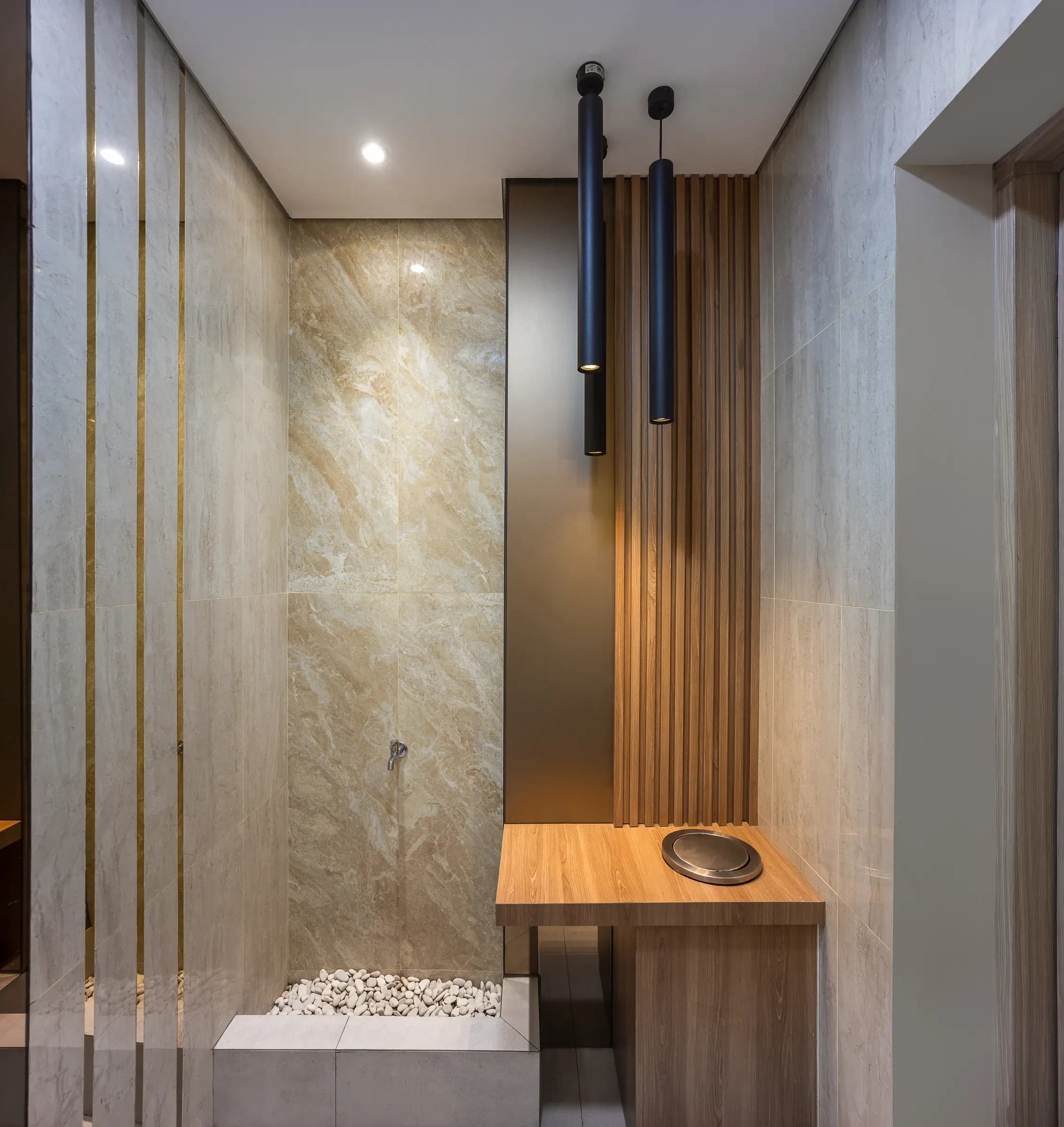 Marble wall with a wooden shelf and pendant lights